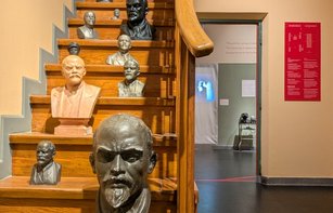 Lenin-Büsten auf einer Holztreppe neben dem Eingang zur Ausstellung „Lenins Tod"
