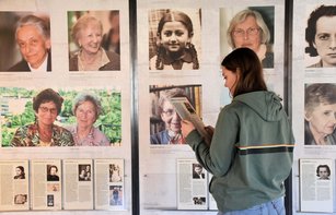 Besucherin in der Ausstellung vor Portraitfotos von Frauen