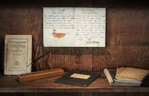 eine Vitrine mit einem Schreibheft mit Füller